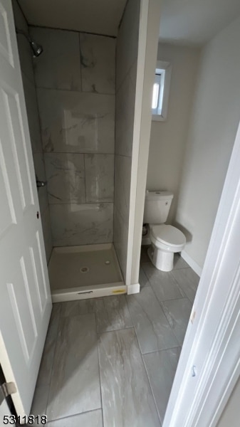 bathroom with toilet and tiled shower