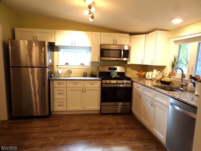 kitchen featuring light stone counters, appliances with stainless steel finishes, dark wood-type flooring, and white cabinetry