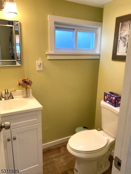 bathroom with hardwood / wood-style flooring, vanity, and toilet