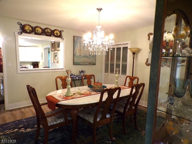 dining area with dark hardwood / wood-style flooring and a chandelier