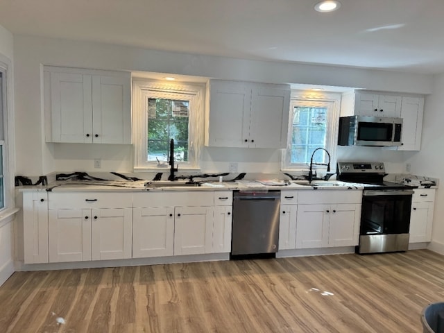 kitchen featuring appliances with stainless steel finishes, white cabinets, and sink