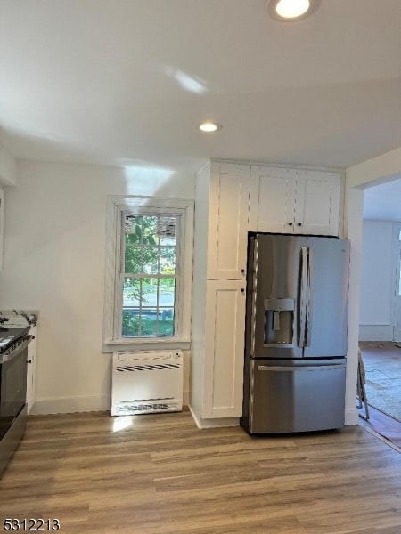 kitchen with stainless steel appliances, light wood-type flooring, and white cabinets