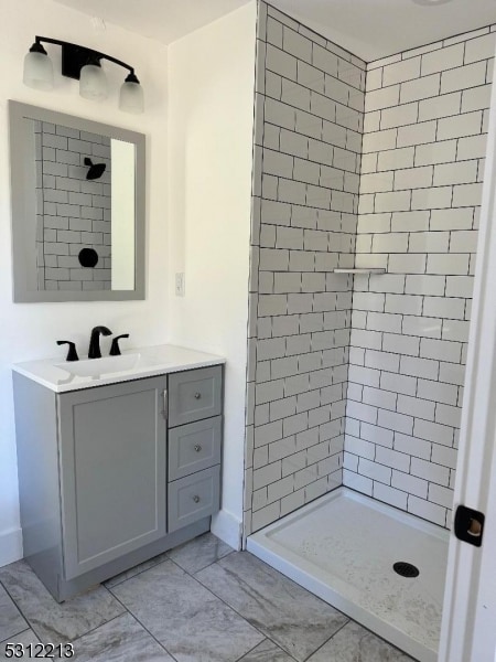 bathroom with vanity and tiled shower