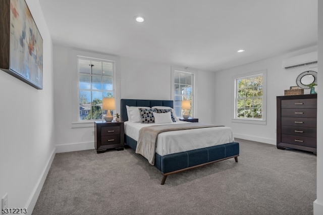 bedroom with an AC wall unit and light carpet