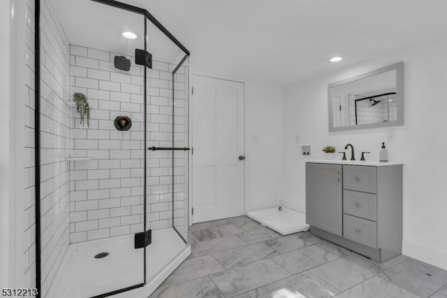 bathroom with a shower with door and vanity