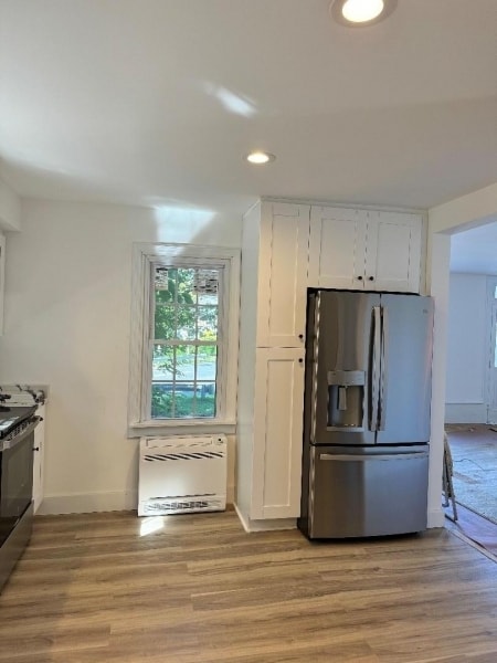 kitchen with white cabinetry, light hardwood / wood-style floors, and stainless steel appliances