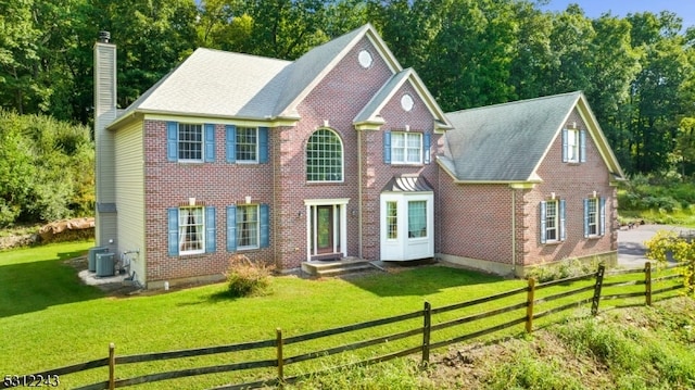 view of front of home featuring central AC unit and a front yard