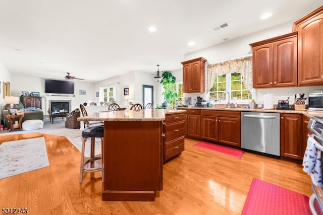 kitchen featuring stainless steel appliances, a kitchen bar, light wood-type flooring, and a kitchen island