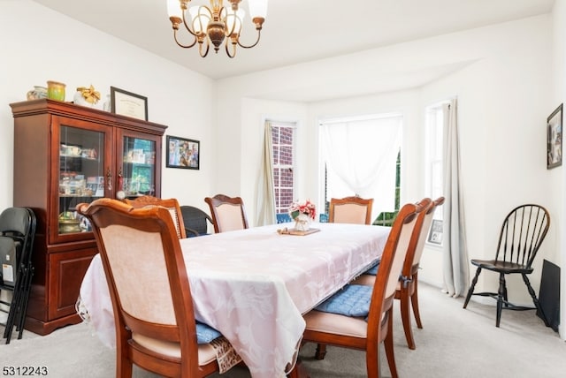 dining room featuring light colored carpet and an inviting chandelier