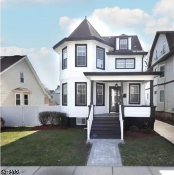 view of front facade with a front lawn and covered porch