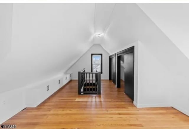 bonus room with lofted ceiling and hardwood / wood-style flooring