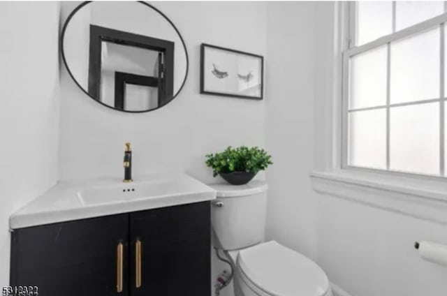 bathroom featuring toilet, plenty of natural light, and vanity