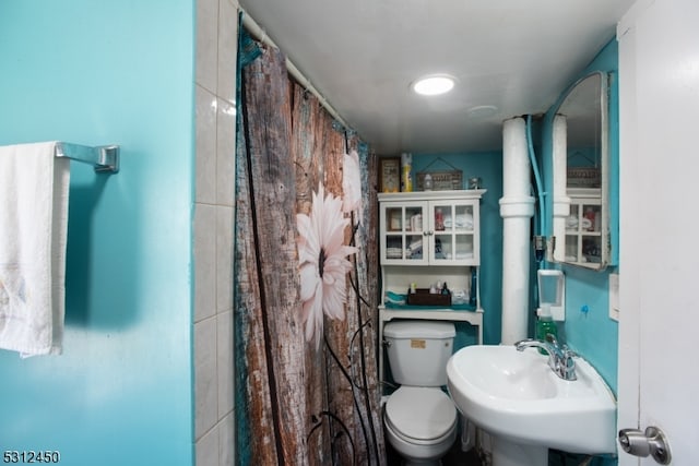 bathroom with a shower with curtain, toilet, and sink