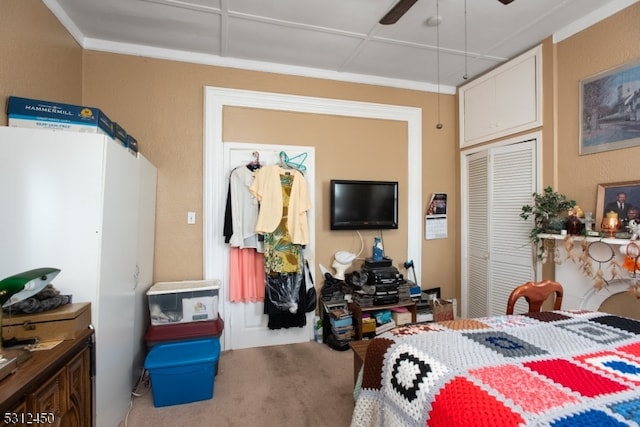 carpeted bedroom with ceiling fan and a closet