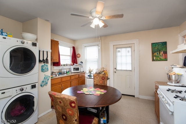 laundry room featuring stacked washing maching and dryer and ceiling fan