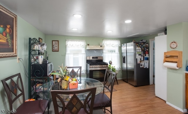 kitchen featuring extractor fan, appliances with stainless steel finishes, and light hardwood / wood-style flooring