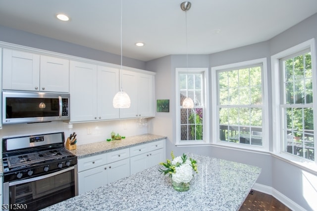 kitchen with white cabinetry, black range with gas cooktop, light stone countertops, and hanging light fixtures