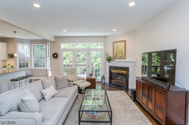 living room featuring a high end fireplace, wood-type flooring, and french doors