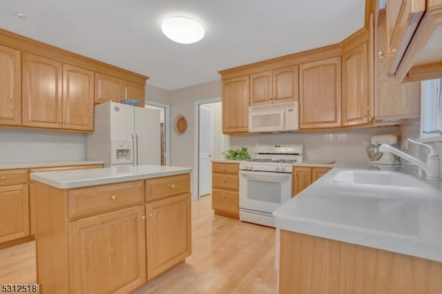 kitchen with white appliances, light hardwood / wood-style flooring, light brown cabinetry, a center island, and sink