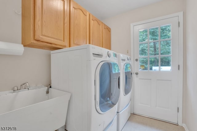 washroom featuring sink, cabinets, and separate washer and dryer