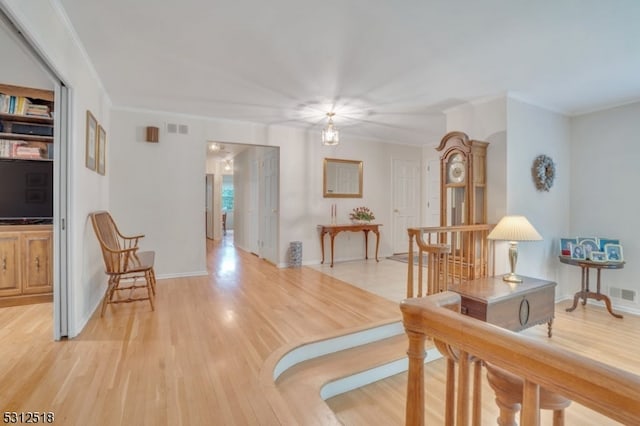 interior space featuring crown molding and light hardwood / wood-style flooring