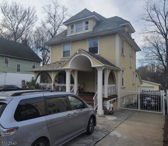 view of property with a garage and a porch