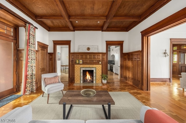 living room featuring ornamental molding, beam ceiling, light hardwood / wood-style floors, and wooden ceiling