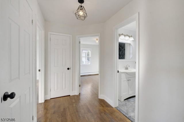 hallway featuring sink, dark hardwood / wood-style flooring, and a baseboard radiator