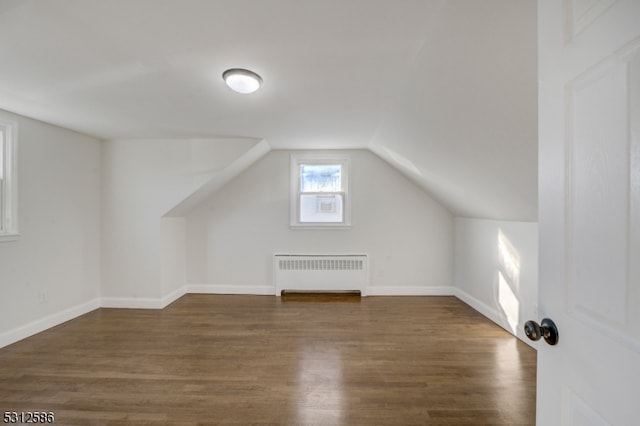 additional living space featuring lofted ceiling, radiator heating unit, and dark hardwood / wood-style floors