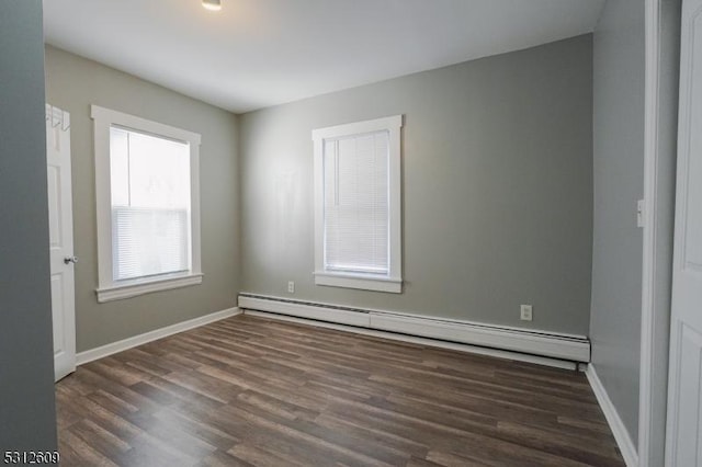 unfurnished room with dark hardwood / wood-style flooring and baseboard heating