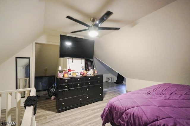 bedroom with light hardwood / wood-style flooring, vaulted ceiling, and ceiling fan