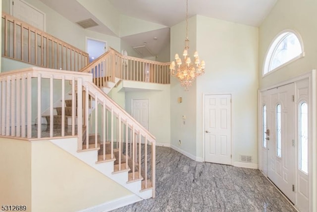 foyer entrance with carpet, high vaulted ceiling, and a notable chandelier