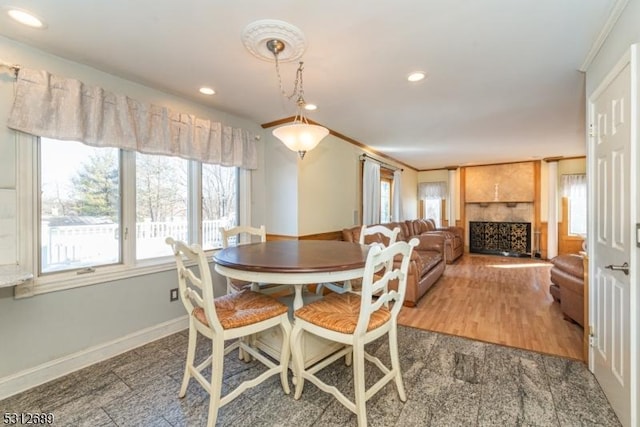 dining room featuring a large fireplace and crown molding