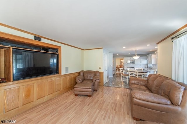 living room featuring light hardwood / wood-style flooring and crown molding