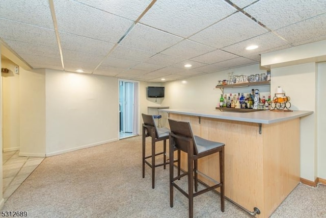 bar featuring light carpet and a drop ceiling