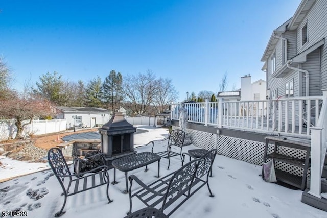 snow covered patio featuring a wooden deck