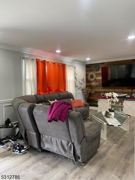 living room with crown molding and hardwood / wood-style floors