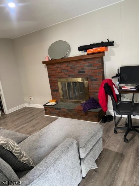 living room featuring a brick fireplace and hardwood / wood-style floors