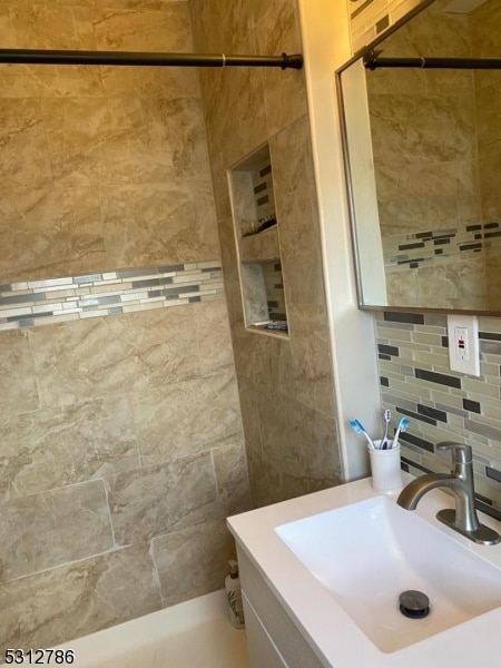 bathroom featuring vanity and backsplash