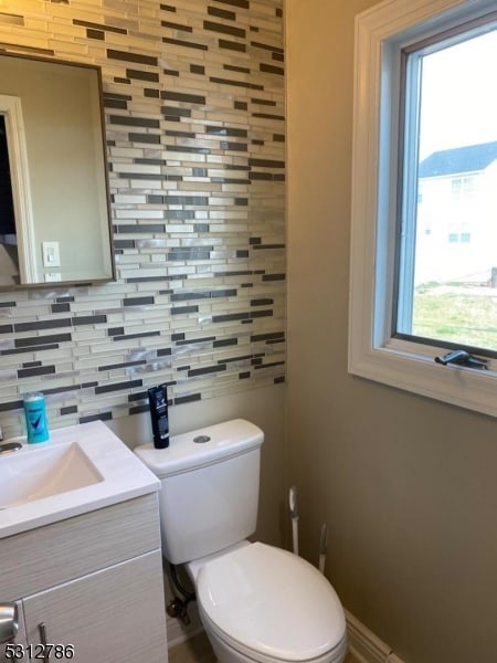 bathroom featuring tasteful backsplash, vanity, and toilet