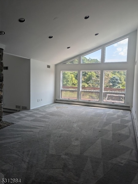 unfurnished room featuring lofted ceiling, a stone fireplace, and carpet floors