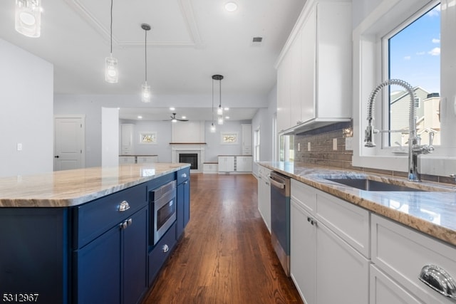 kitchen featuring appliances with stainless steel finishes, blue cabinets, sink, white cabinets, and dark hardwood / wood-style floors