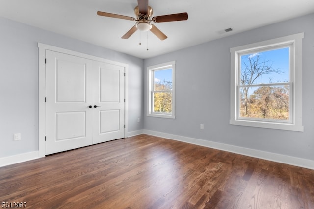 unfurnished bedroom featuring dark hardwood / wood-style flooring, a closet, and ceiling fan