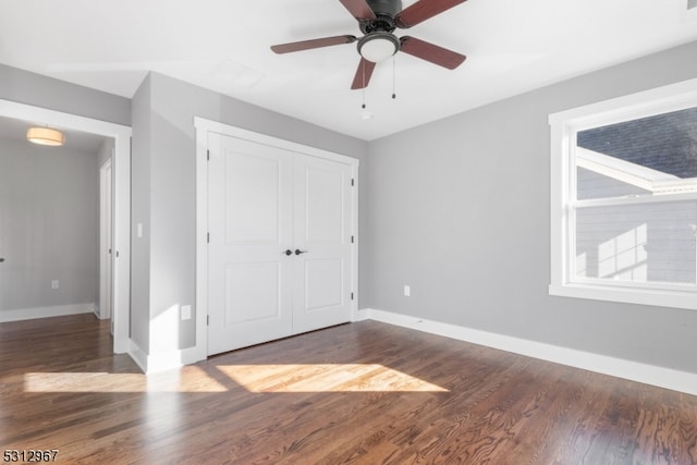 unfurnished bedroom featuring ceiling fan, a closet, and dark hardwood / wood-style floors