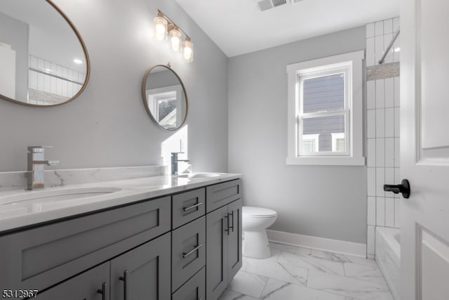 full bathroom featuring vanity, toilet, and tiled shower / bath combo