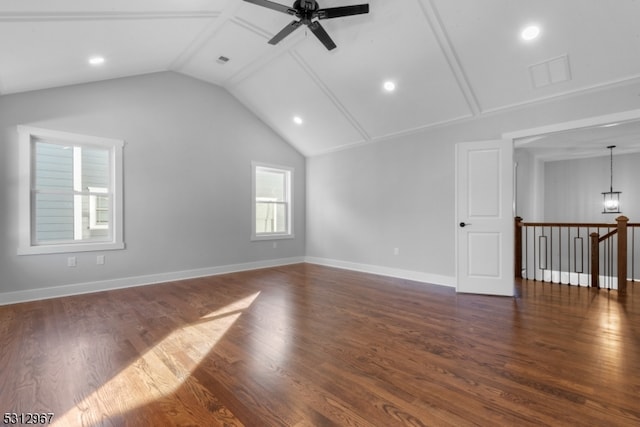 unfurnished living room featuring ceiling fan with notable chandelier, vaulted ceiling, and dark wood-type flooring