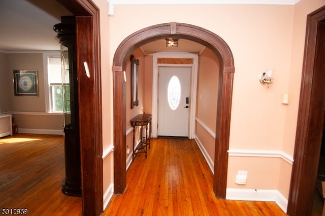 doorway featuring crown molding and hardwood / wood-style flooring