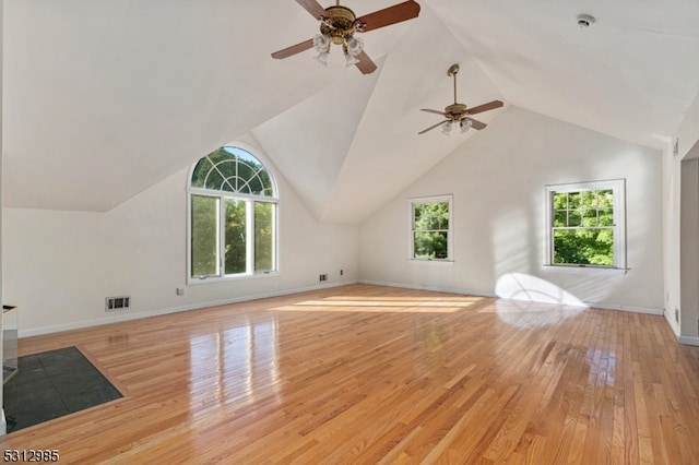 additional living space with light wood-type flooring, vaulted ceiling, a healthy amount of sunlight, and ceiling fan