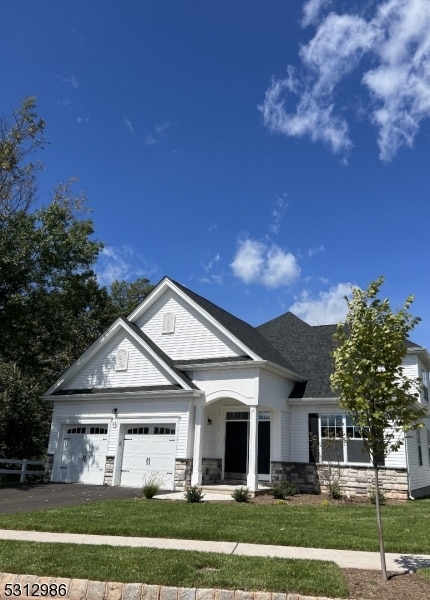 view of front of house with a garage and a front lawn