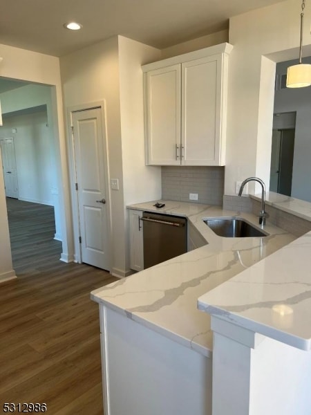 kitchen with white cabinets, kitchen peninsula, decorative light fixtures, dark hardwood / wood-style floors, and sink